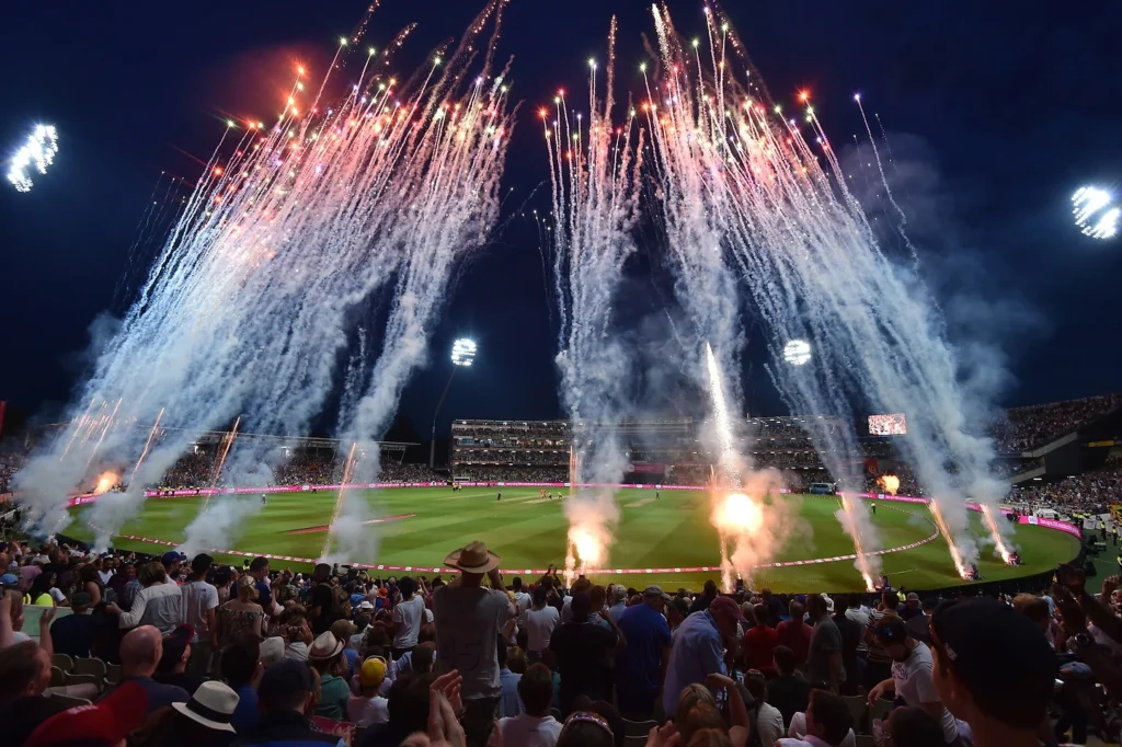 Spectacular fireworks display at a cricket match during a night game.